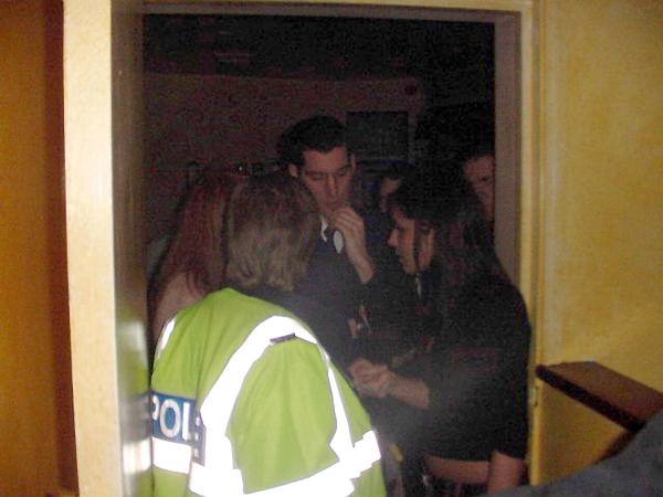 11-01-03 CHERYL (RIGHT) IS ARRESTED BY GUILDFORD POLICE AFTER A BRAWL IN THE DRINK NIGHT CLUB. (OTHER BAND MEMBER NICOLA IS ON THE LEFT OBSCURED BY POLICE WOMAN).