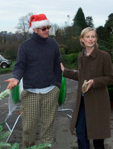 01/12/2001 -Ever wondered what Chris Evans has been doing since being sacked by Virgin.  We can exclusively reveal that he has set up shop to sell Christmas trees outside his local public house in Hascombe  The trees start at £25. with Chris is Ceri Drewett, of Godalming, one happy customer